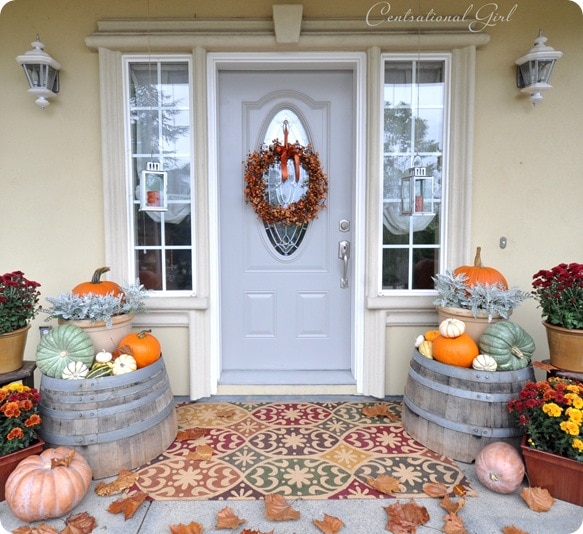 10 Fall Front Porch Decorating Ideas by A Blissful Nest - This front porch fall decor is orchestrated perfectly with rustic barrels and a beautiful accent rug to pull all those rich colors together. 