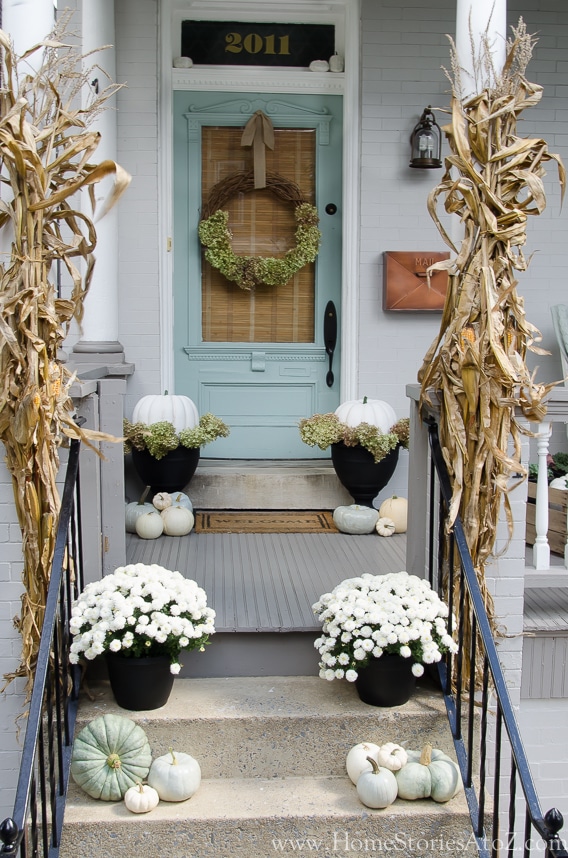 10 Fall Front Porch Decorating Ideas by A Blissful Nest - This front porch fall decor looks fresh and colorful with the pale blue door and matching pumpkin accents. 