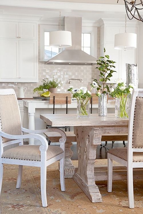 All- white kitchens work best when complimented with colors. This neutral color scheme on the chairs, carpet, and beautiful wood dining table make this kitchen look bright and welcoming. 