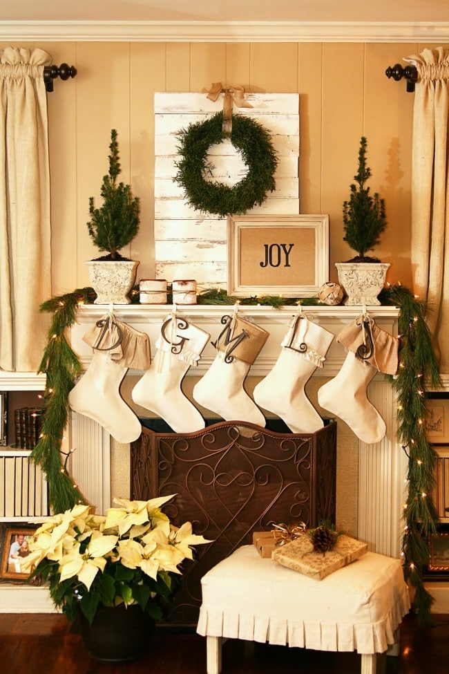 Christmas mantels - yellow, gold, white, and cream color scheme with poinsettia plant and pine wreath - Christmas Mantels - The Butlers