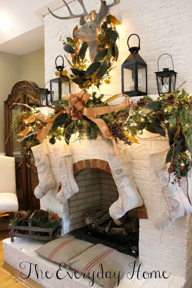 Christmas mantels - rustic country style fireplace with gold and green wreaths, deer head, burlap ribbons - Christmas Mantel The Everyday Home