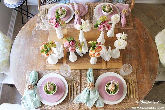 A beautiful and soft Easter table decor setting that is the perfect transition into spring. Soft whites with pops of flowers and pastels makes this Easter table setting perfect for your family! Check out more of this table on ablissfulnest.com