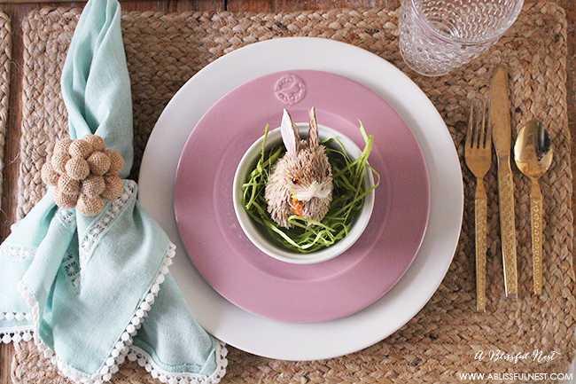 A beautiful and soft Easter table decor setting that is the perfect transition into spring. Soft whites with pops of flowers and pastels makes this Easter table setting perfect for your family! Check out more of this table on ablissfulnest.com