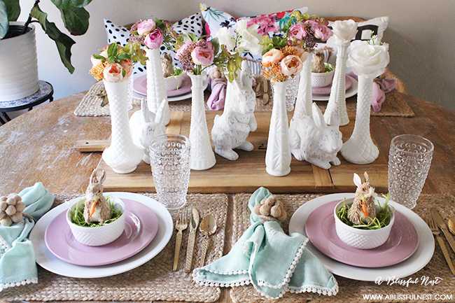 A beautiful and soft Easter table decor setting that is the perfect transition into spring. Soft whites with pops of flowers and pastels makes this Easter table setting perfect for your family! Check out more of this table on ablissfulnest.com