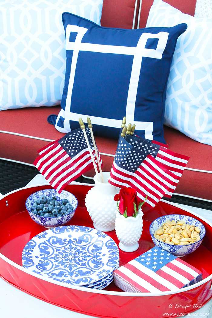 These are such great ideas to celebrate 4th of July with! I love all the Americana red, white and blue pops of color on this patio. Check out more on A Blissful Nest. https://ablissfulnest.com #4thofjuly #4thofjulydecor #redwhiteandblue