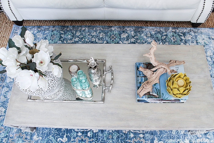 Keep the coastal theme alive with crafty centerpieces of chunky driftwood and aqua blue and white accents. 