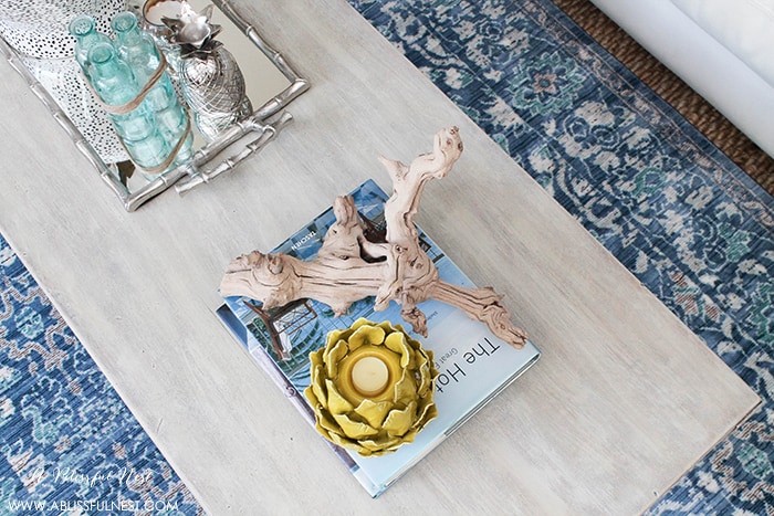 If you love the coastal driftwood look then this is for you! Learn the easiest way to get a weathered wood finish featured on this coffee table makeover by A Blissful Nest. https://ablissfulnest.com/ #coastal #homedecor #diytutorial #tablemakeover #livingroom #driftwood #fauxfinish #weatheredwood