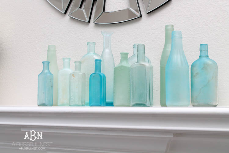 Such an easy tutorial on how to create DIY sea glass bottles using spray paint. Literally 2 steps to get this coastal décor look! See how on https://ablissfulnest.com/ #coastaldecorating #seaglassbottle #designtips #howtomake #diyseaglassbottles