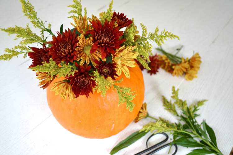 A super cute and simple DIY pumpkin centerpiece idea perfect for a fall table or Thanksgiving table idea! See more on https://ablissfulnest.com/ #falltable #pumpkinideas #falldecor