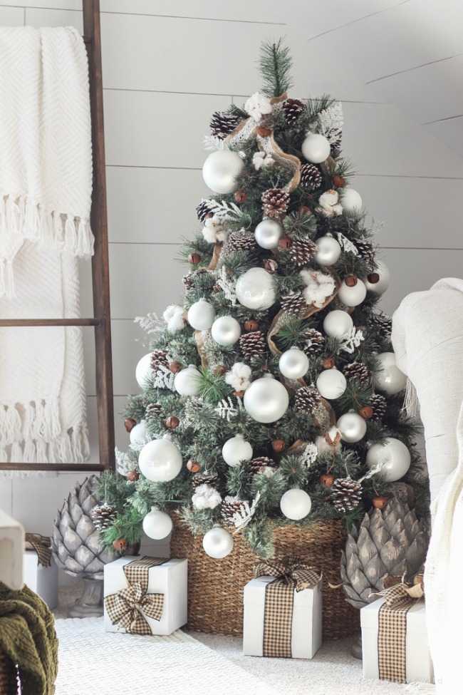 The oversized ornaments and snow-dusted pine cones give this decorated christmas tree a very crafty feel