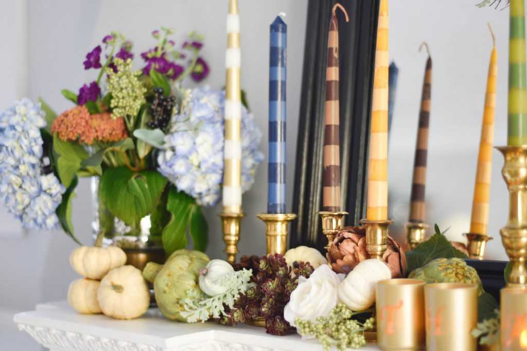 Learn how to make your own striped taper candles and painted votive candle holders for any occasion. A gorgeous Thanksgiving mantel brimming with color. See it all at https://ablissfulnest.com/ #Thanksgiving #DIY #HolidayDIY