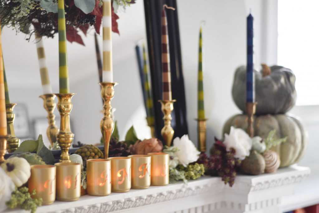 Learn how to make your own striped taper candles and painted votive candle holders for any occasion. A gorgeous Thanksgiving mantel brimming with color. See it all at https://ablissfulnest.com/ #Thanksgiving #DIY #HolidayDIY