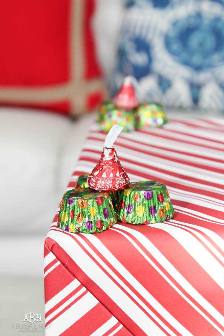 Wrap your presents in chocolaty goodness with Hershey’s Kisses! This is such a fun and unique idea to decorate a gift. Then they can eat the candy later after the present has been opened! So fun! See more on https://ablissfulnest.com/ #hersheyskiss #christmascraft #christmasdiyidea