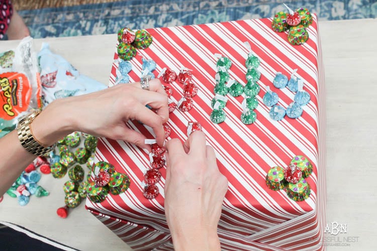 Wrap your presents in chocolaty goodness with Hershey’s Kisses! This is such a fun and unique idea to decorate a gift. Then they can eat the candy later after the present has been opened! So fun! See more on https://ablissfulnest.com/ #hersheyskiss #christmascraft #christmasdiyidea