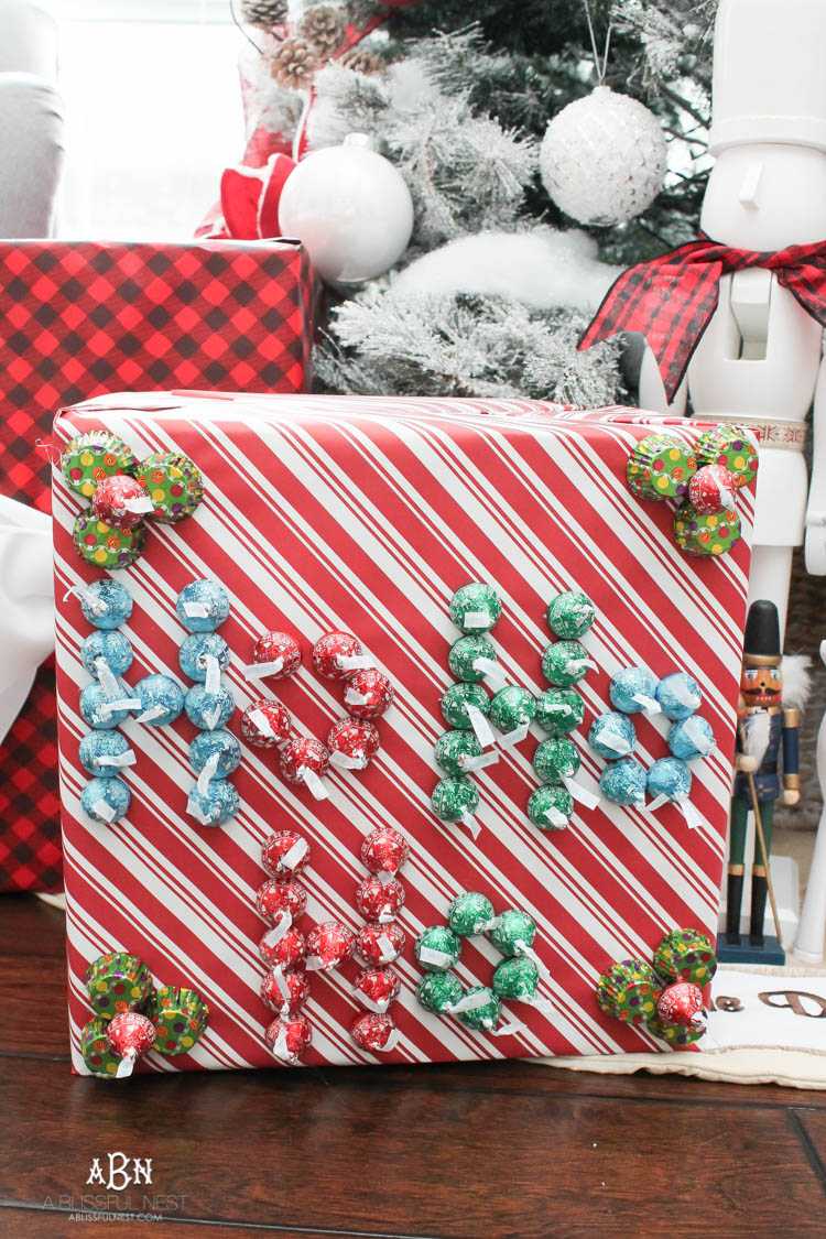 Wrap your presents in chocolaty goodness with Hershey’s Kisses! This is such a fun and unique idea to decorate a gift. Then they can eat the candy later after the present has been opened! So fun! See more on https://ablissfulnest.com/ #hersheyskiss #christmascraft #christmasdiyidea