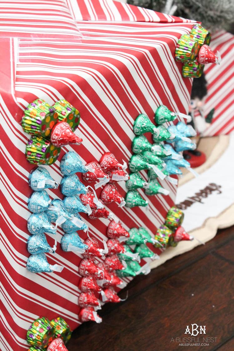 Wrap your presents in chocolaty goodness with Hershey’s Kisses! This is such a fun and unique idea to decorate a gift. Then they can eat the candy later after the present has been opened! So fun! See more on https://ablissfulnest.com/ #hersheyskiss #christmascraft #christmasdiyidea