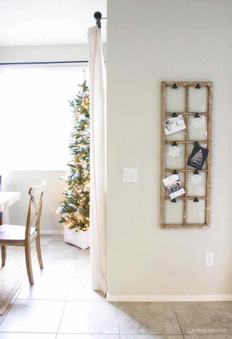 Use an old window and some clips to create a one-of-a-king Christmas card display. It makes for a beautiful decor piece in your home! See it all on https://ablissfulnest.com/ #Christmas #CHristmasCards #VintageDecor