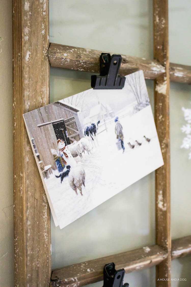 Use an old window and some clips to create a one-of-a-king Christmas card display. It makes for a beautiful decor piece in your home! See it all on https://ablissfulnest.com/ #Christmas #CHristmasCards #VintageDecor