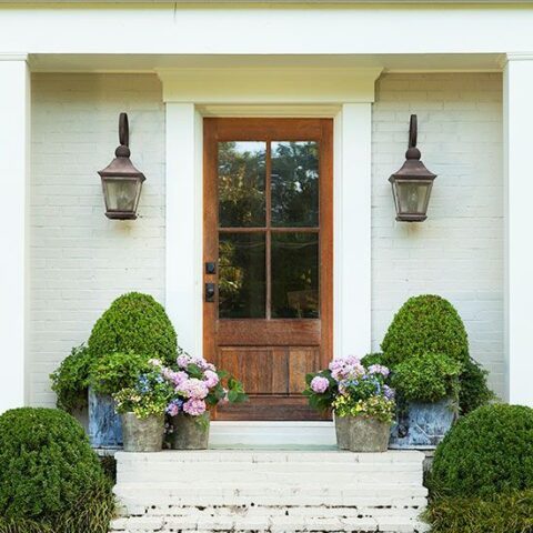 Add lots of potted plants to your front porch for spring. Love this beautiful spring front porch. #spring #springporch #springdecorating #springfrontporch