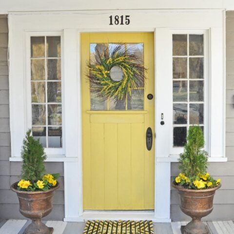 Love the bright sunny yellow color of this spring front porch door! #spring #springporch #springdecorating #springfrontporch