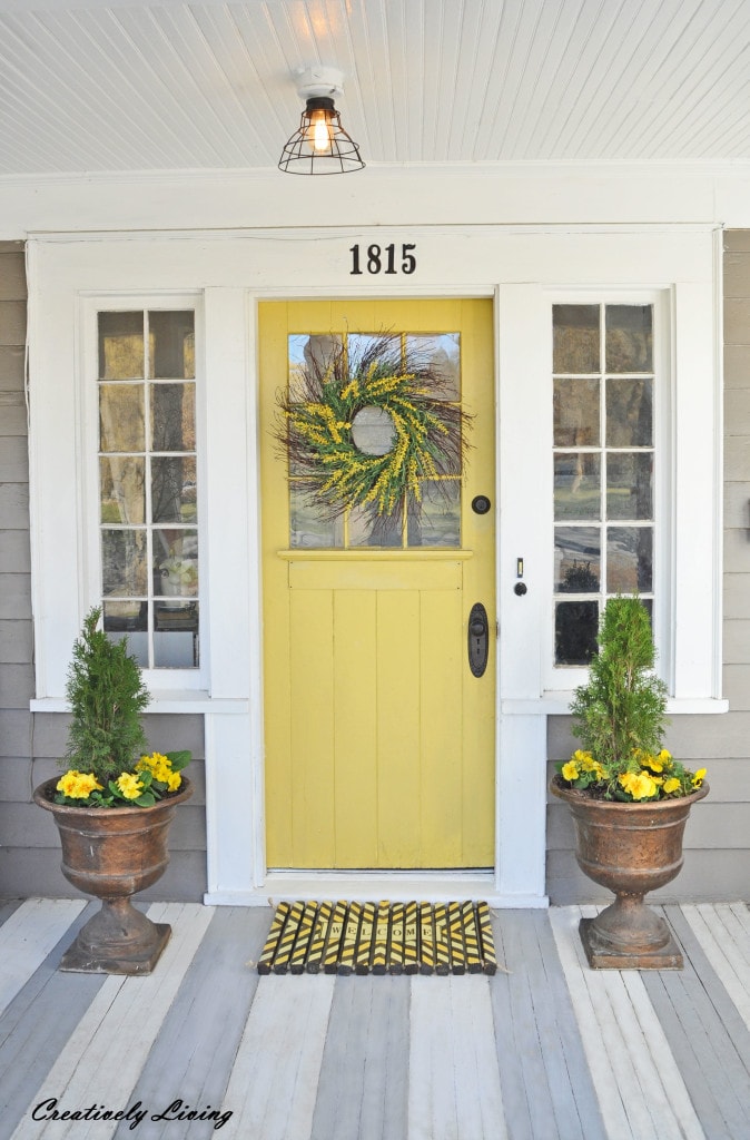 Love the bright sunny yellow color of this spring front porch door! #spring #springporch #springdecorating #springfrontporch