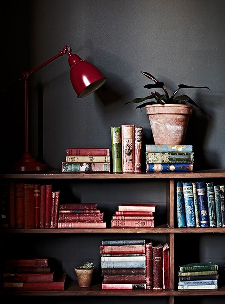 Collection of burgundy and blue books on a wood shelf