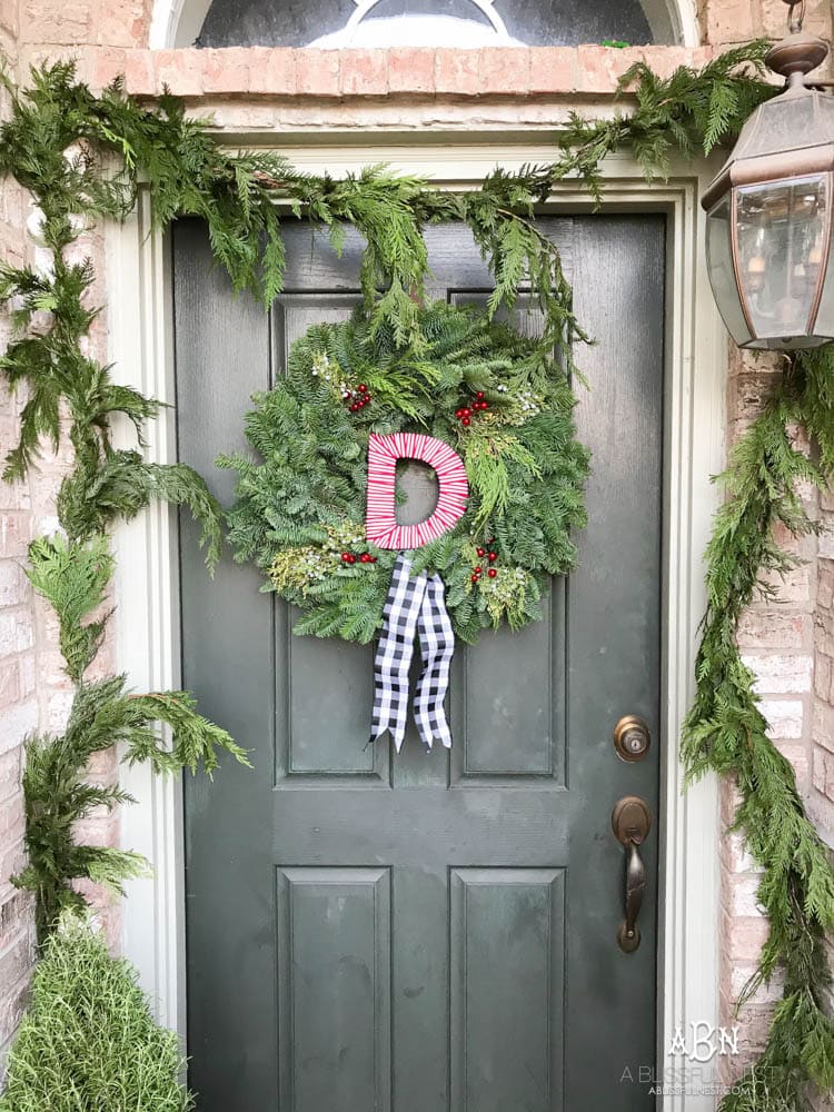 A classic christmas porch and beautiful neutral Christmas dining room idea. See more on https://ablissfulnest.com/ #christmasdecor #christmasideas #christmasfront porch #christmasdecoratingideas