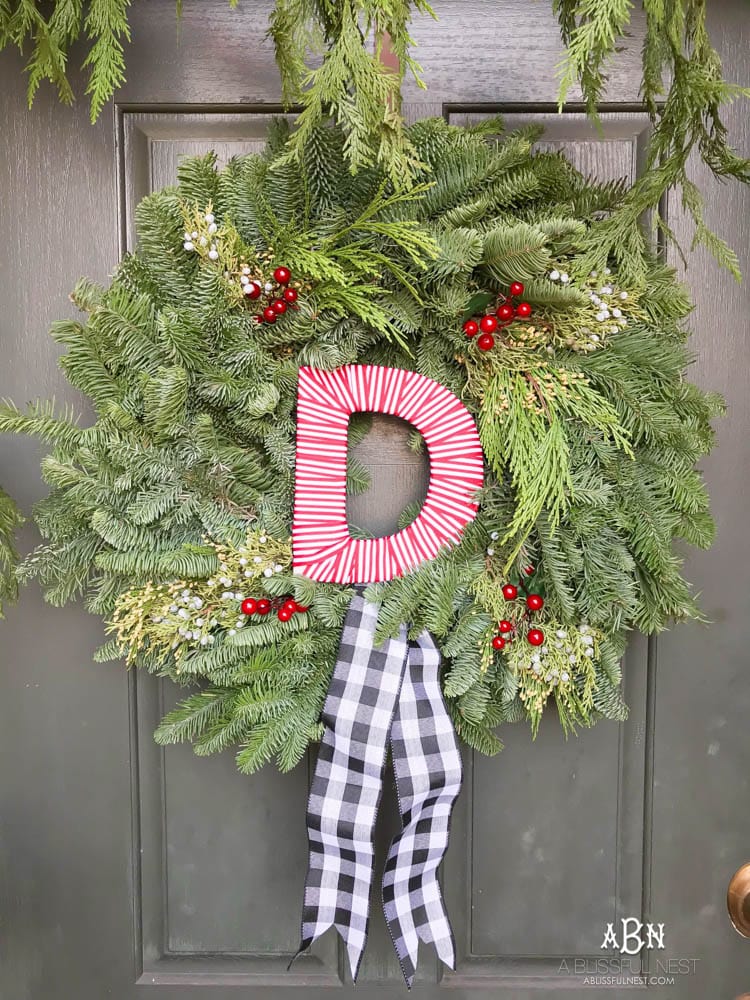 A classic christmas porch and beautiful neutral Christmas dining room idea. See more on https://ablissfulnest.com/ #christmasdecor #christmasideas #christmasfront porch #christmasdecoratingideas