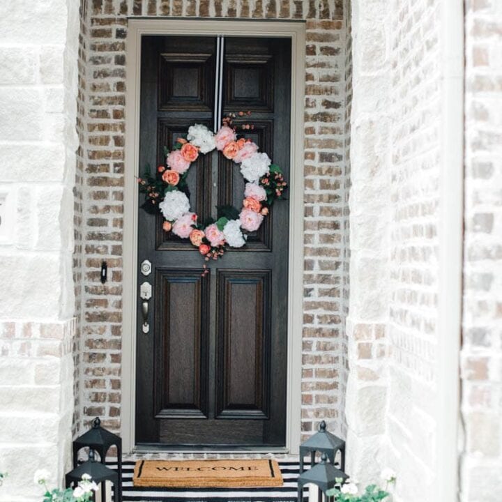 Adding pop of pinks a a DIY wreath makes this spring porch pop! #springporch #springfrontporch #springdecorating #springdecoratingideas