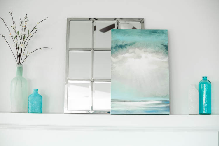 Turquoise accents and a pretty ocean art print. #ad #AthomeStores #springdecorating #springdecoratingideas #coastallivingroom