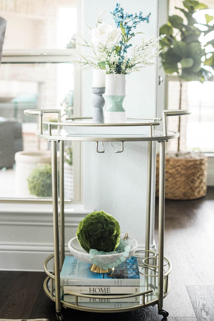 Add faux florals and a candle to a bar cart for some spring touches. #ad #AthomeStores #springdecorating #springdecoratingideas #coastallivingroom