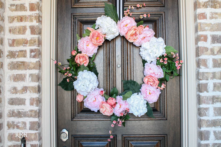 Adding pop of pinks a a DIY wreath makes this spring porch pop! #springporch #springfrontporch #springdecorating #springdecoratingideas
