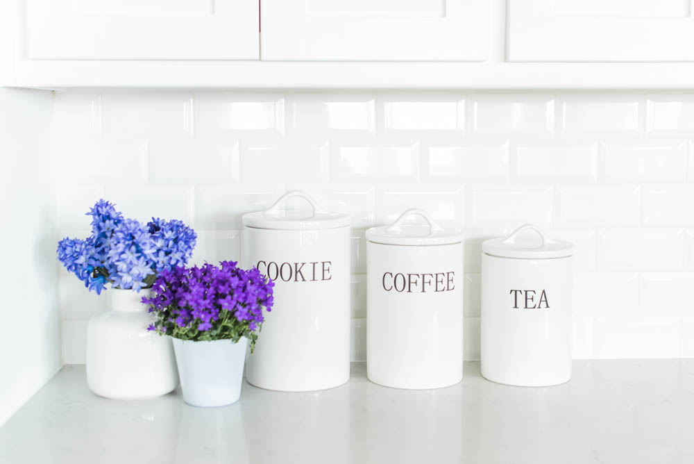 Beautiful summer accents in this all white kitchen. More white kitchen ideas on https://ablissfulnest.com #ABlissfulNest #whitekitchen #kitcheninspiration #kitchenideas