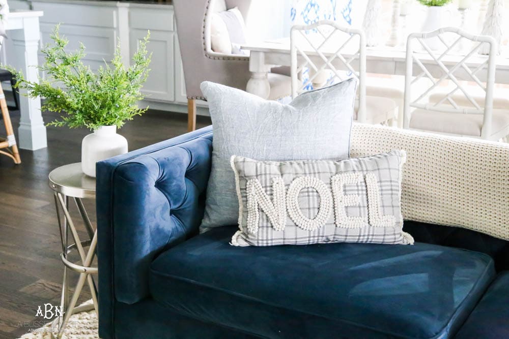 Beautiful blue and silver Christmas living room decor in a bright white space with juniper garland and silver and blush ornaments. Check out all the white, silver and gold Christmas decor in this holiday home tour on ABlissfulNest.com. #ABlissfulNest #Christmasdecor #Christmasdecorating #CoastalChristmasdecor #christmastree #christmasmantle