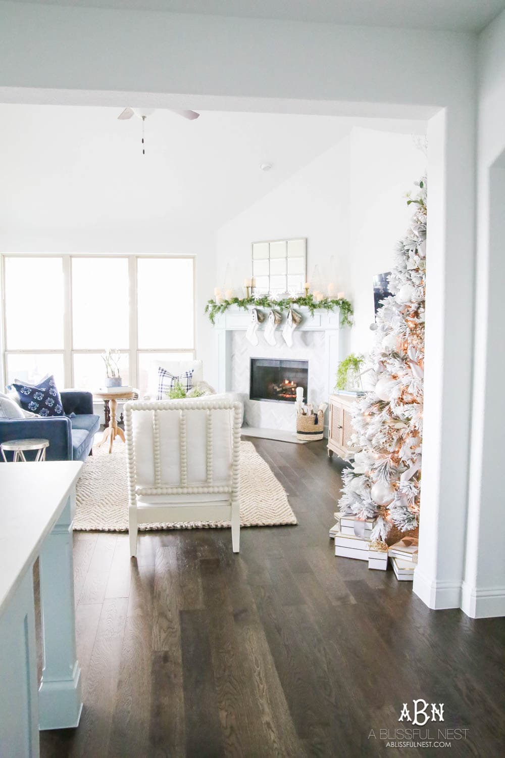 Silver and gold Christmas tree in an open concept floor plan with lots of blue home decor accents. Check out all the white, silver and gold Christmas decor in this holiday home tour on ABlissfulNest.com. #ABlissfulNest #Christmasdecor #Christmasdecorating #CoastalChristmasdecor #christmastree