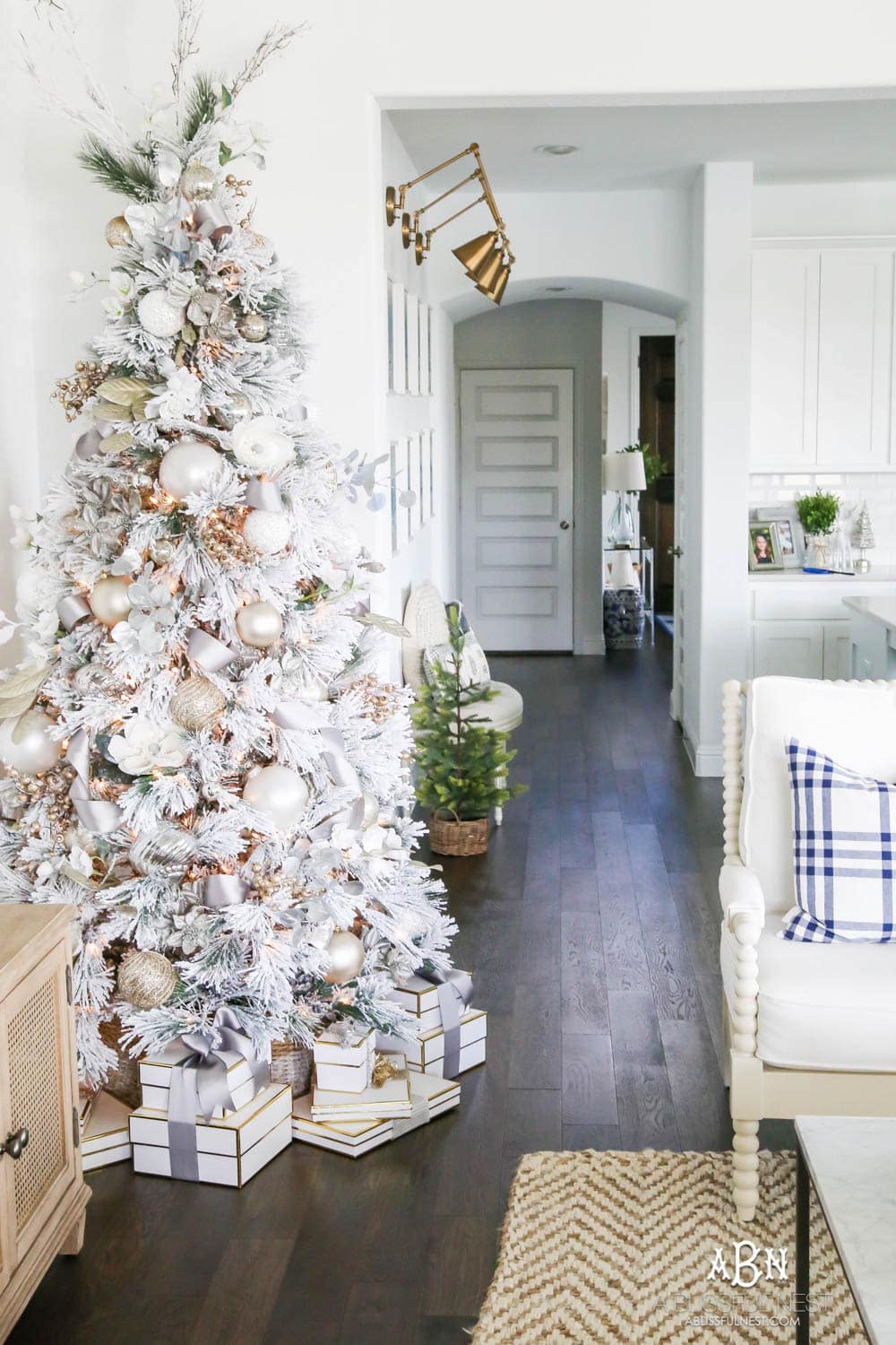 Silver and gold Christmas tree in an open concept floor plan with lots of blue home decor accents. Check out all the white, silver and gold Christmas decor in this holiday home tour on ABlissfulNest.com. #ABlissfulNest #Christmasdecor #Christmasdecorating #CoastalChristmasdecor