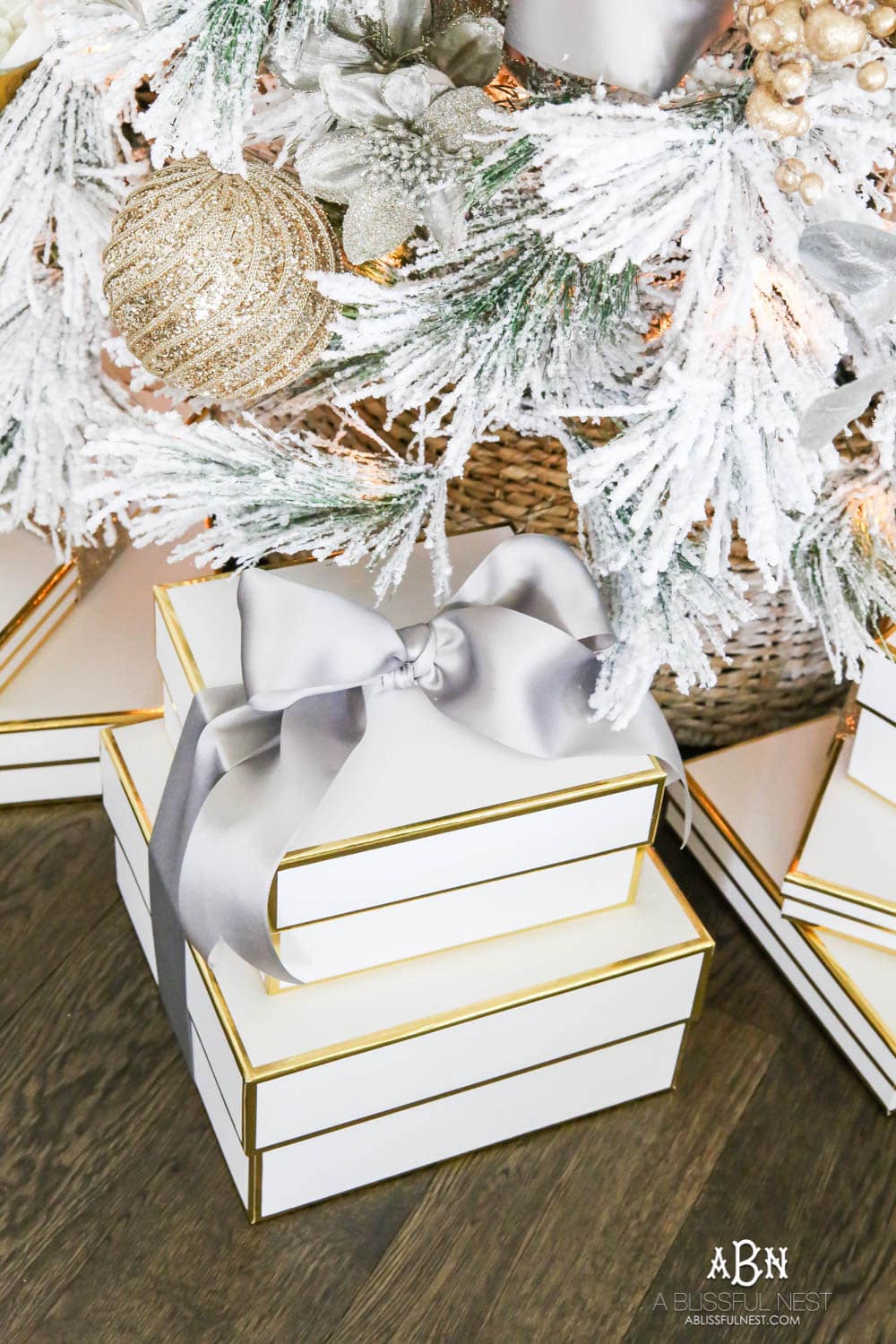 White boxes with gold trim make the perfect wrapping for gifts under this white flocked tree with silver and gold accents. Check out all the white, silver and gold Christmas decor in this holiday home tour on ABlissfulNest.com. #ABlissfulNest #Christmasdecor #Christmasdecorating #CoastalChristmasdecor #christmastree