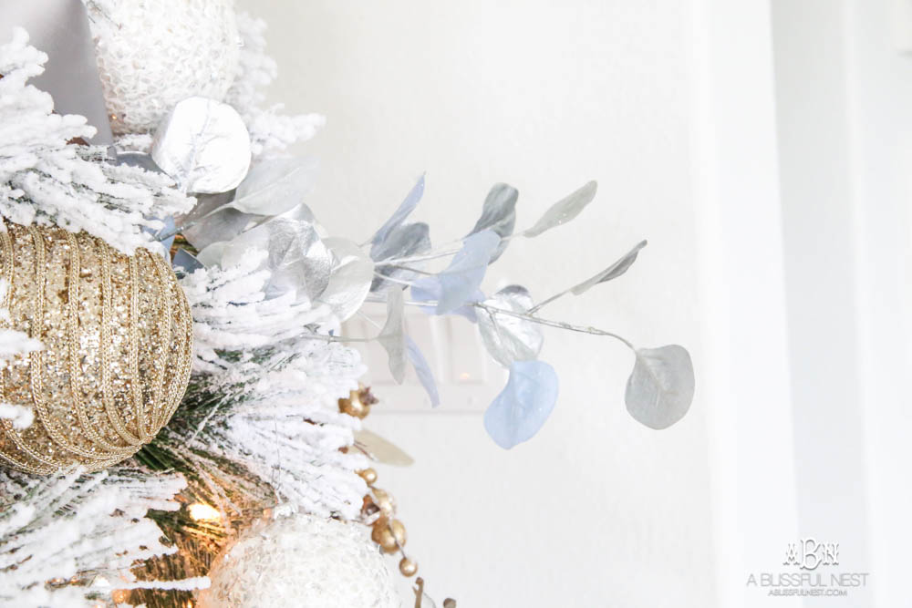 Silver and gold Christmas tree in an open concept floor plan with lots of blue home decor accents. Check out all the white, silver and gold Christmas decor in this holiday home tour on ABlissfulNest.com. #ABlissfulNest #Christmasdecor #Christmasdecorating #CoastalChristmasdecor