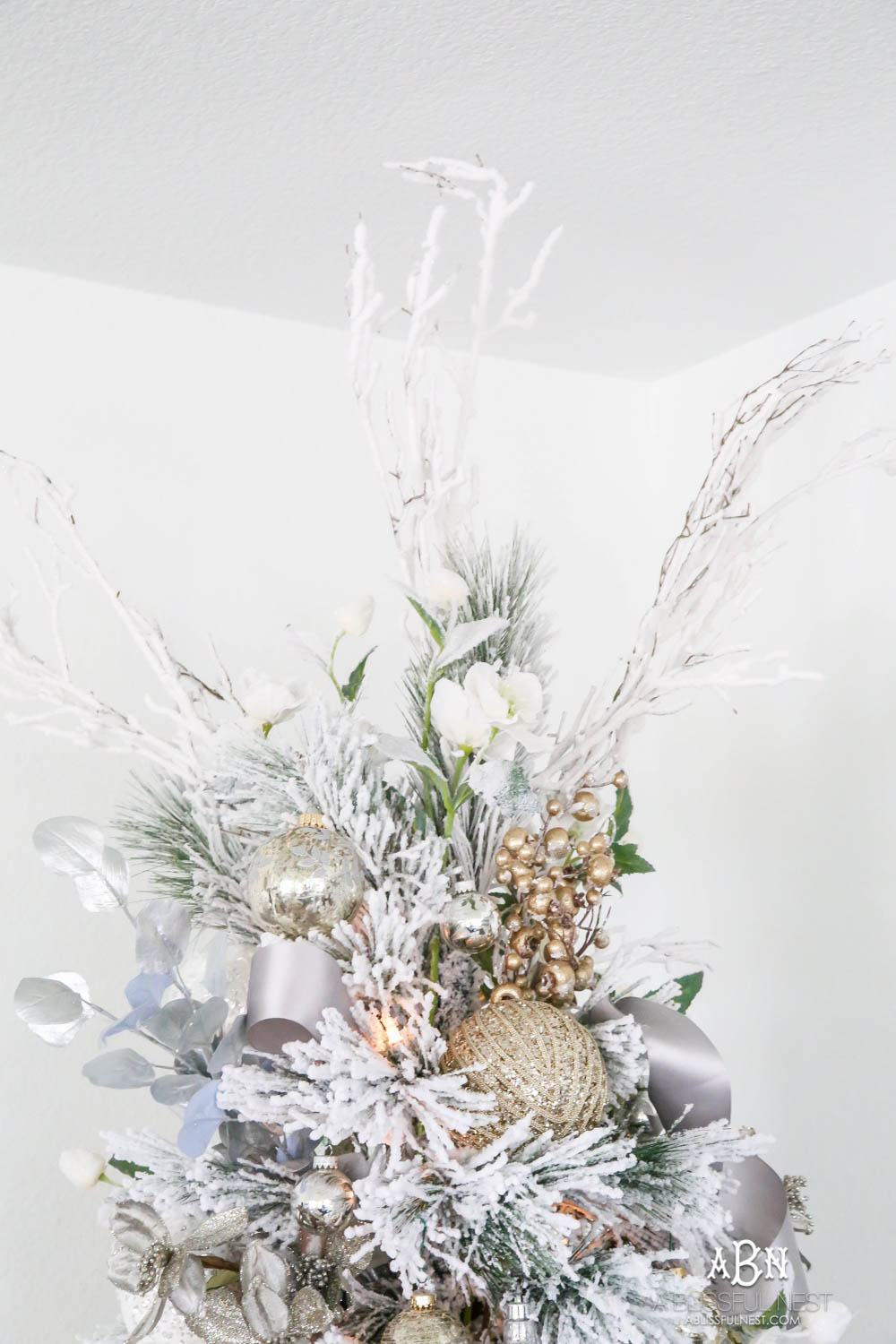 Silver and gold Christmas tree in an open concept floor plan with lots of blue home decor accents. Check out all the white, silver and gold Christmas decor in this holiday home tour on ABlissfulNest.com. #ABlissfulNest #Christmasdecor #Christmasdecorating #CoastalChristmasdecor #christmastree