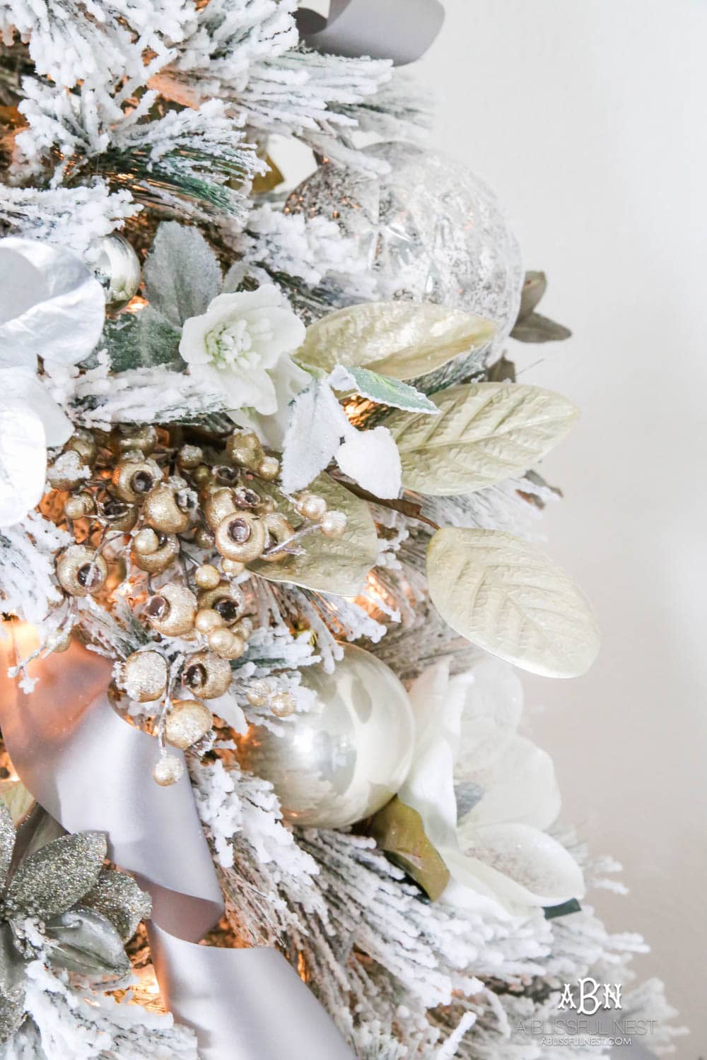 Silver and gold Christmas tree in an open concept floor plan with lots of blue home decor accents. Check out all the white, silver and gold Christmas decor in this holiday home tour on ABlissfulNest.com. #ABlissfulNest #Christmasdecor #Christmasdecorating #CoastalChristmasdecor