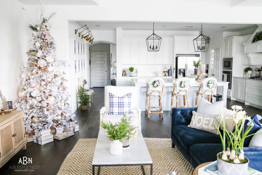 Beautiful blue and silver Christmas living room decor in a bright white space with juniper garland and silver and blush ornaments. Check out all the white, silver and gold Christmas decor in this holiday home tour on ABlissfulNest.com. #ABlissfulNest #Christmasdecor #Christmasdecorating #CoastalChristmasdecor