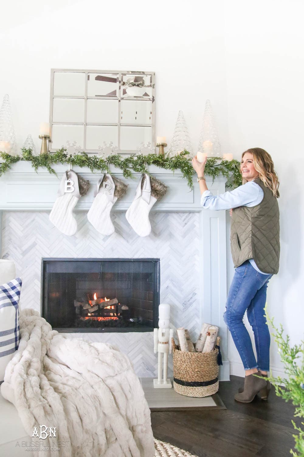 Gorgeous blue and silver Christmas mantle décor with juniper berry garland and glass hurricane Christmas trees. Simple and festive holiday décor in this open concept living space. Check out all the white, silver and gold Christmas decor in this holiday home tour on ABlissfulNest.com. #ABlissfulNest #Christmasdecor #Christmasdecorating #CoastalChristmasdecor #christmastree #christmasmantle