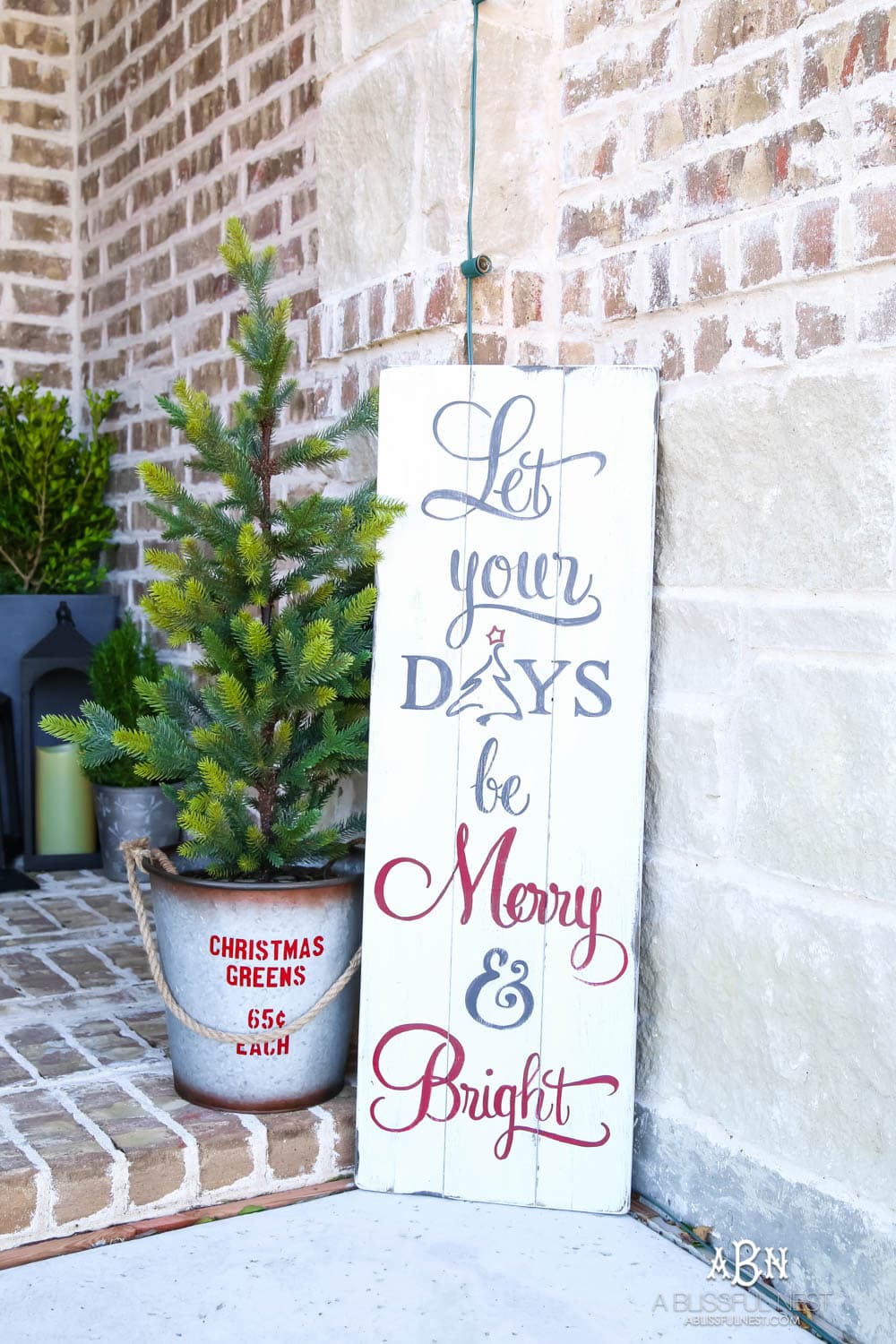 Classic Christmas front porch with red, white and black details. Festive plaid door mat and simple black lanterns. Red Christmas balls on a beautiful Christmas wreath. #christmasporch #christmasfrontporch #christmasporchdecor #christmasporchideas #christmashometou