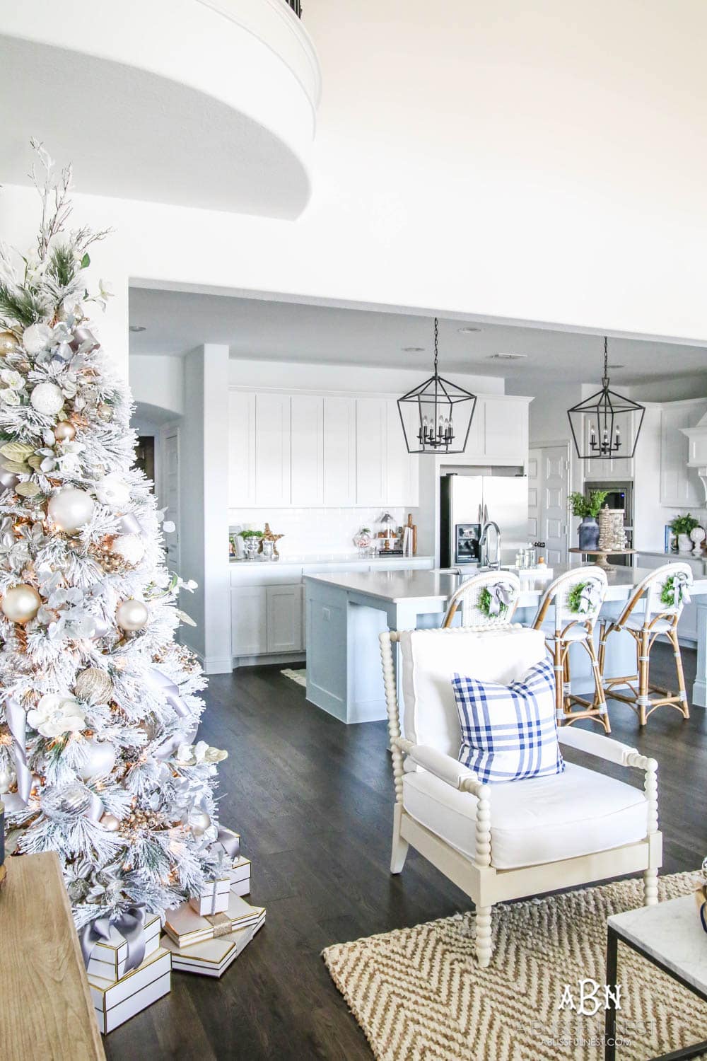Blue and silver Christmas kitchen décor. All white kitchen with subtle holiday décor for a fresh coastal Christmas look. Mini wreaths on the backs of the barstools, beautiful bay leaf above the range. #christmaskitchen #christmashometour #holidayhometour #kitchenideas