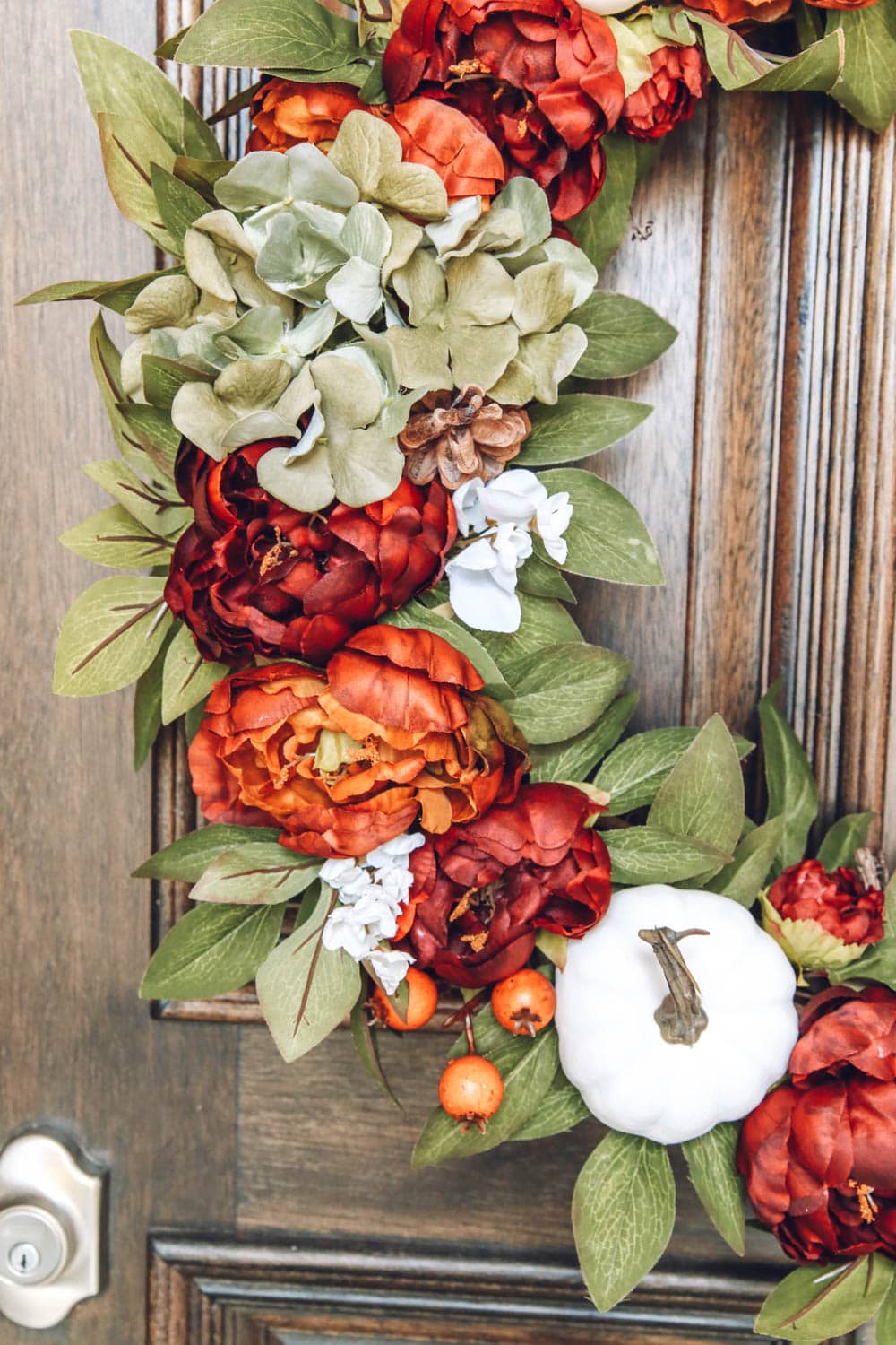 Beautiful burnt orange, muted green, mini pumpkins, hydrangea and small berries. Gorgeous fall wreath details. #ABlissfulNest #fallporch #fallinspiration