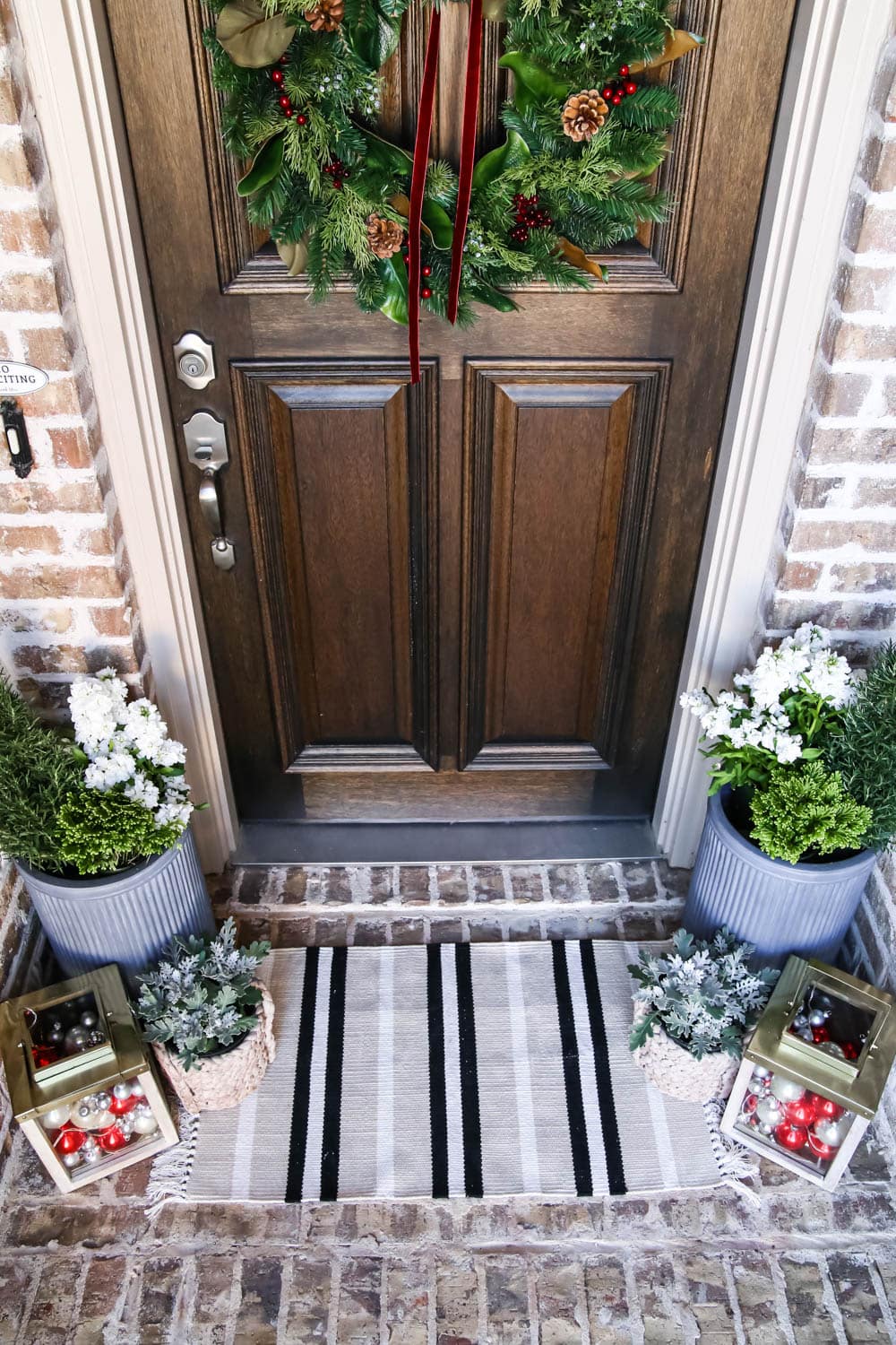 A striped door mat adds a fun pop to this Christmas porch. #ABlissfulNest #christmasporch #christmasdecor