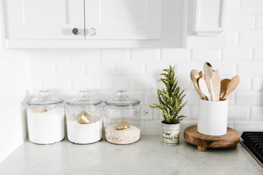 Christmas decor in a bright white kitchen. Baking canisters on Carrara counter. #ABlissfulNest #Christmaskitchen #whitekitchen