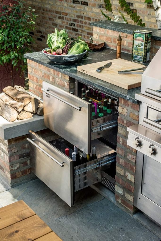 outdoor kitchen bar built with brick and stainless steel drawers and grill