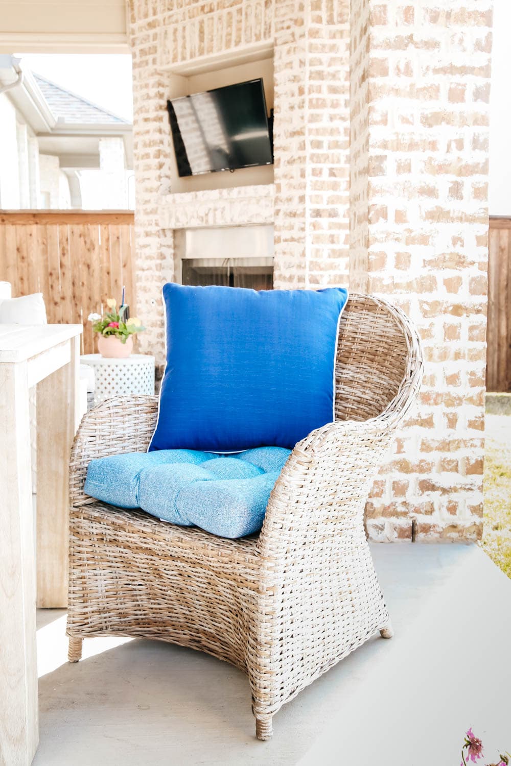 blue cushions, wicker chairs, brick fireplace, spring patio decor. #ABlissfulNest #patio #outdoor #backyard