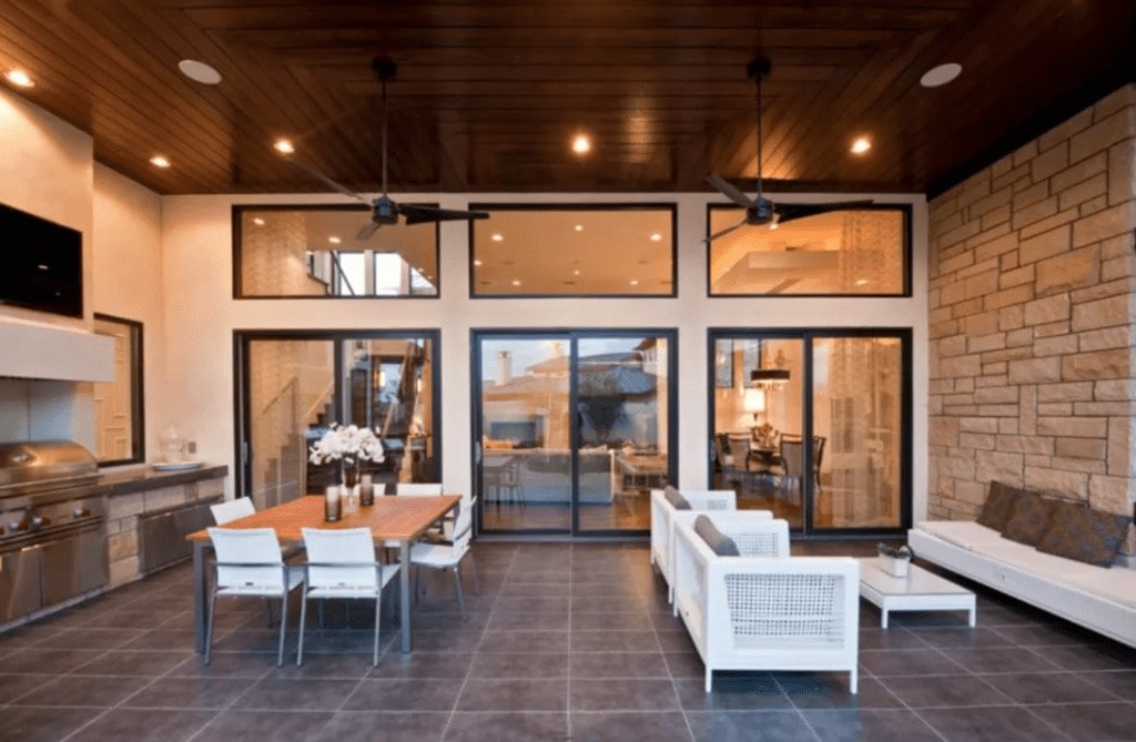 outdoor kitchen bar built into a wall with a large dining table and sofa